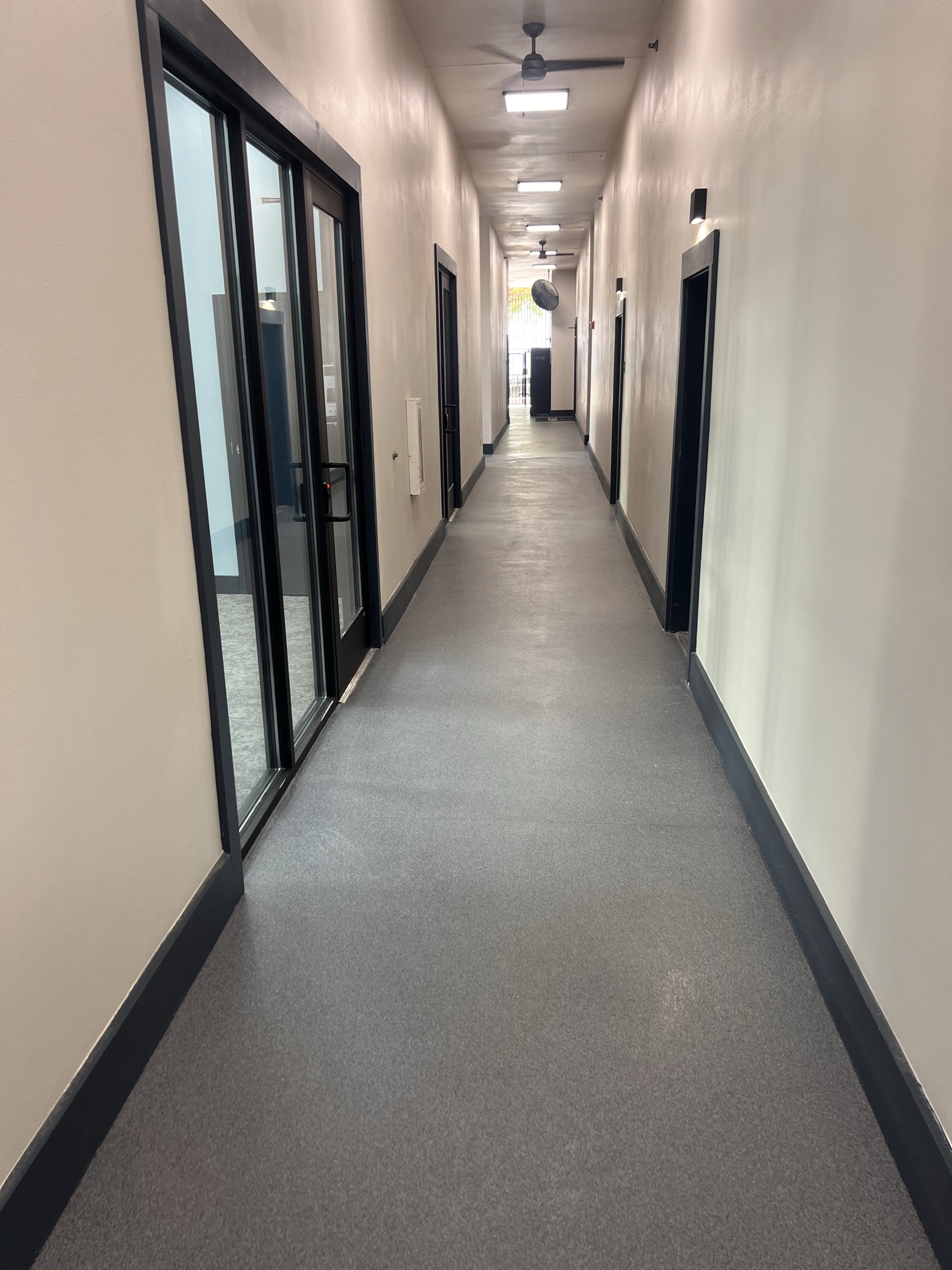 Completed gray Rezena Quartz floor in a long commercial corridor